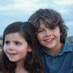Image description: Annie Cohane and her big brother Petey at the beach. Annie was diagnosed with Leber congenital amaurosis (LCA) at 3 months of age. Genetic testing later showed a mutation in her CEP290 gene. 