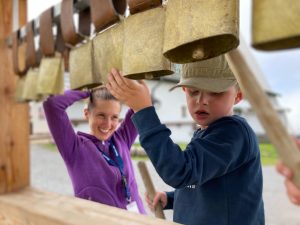 Young boy and woman with cow bells.