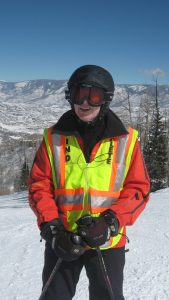 Man on ski mountain wearing vest that says BLIND ATHLETE