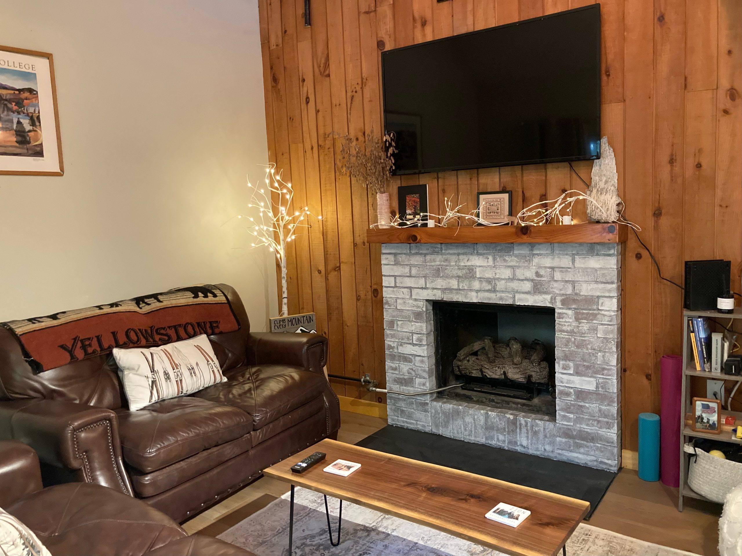 cozy room with leather couches, TV over fireplace