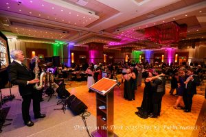A wide shot of a band playing and attendees dancing.